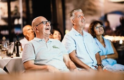 אנשים מבוגרים צוחקים ונהנים מצפיה בערב אירוע במסעדת פורט לוקאל ביסטרו