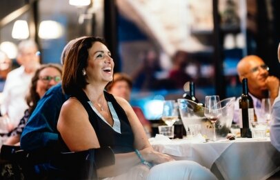 אישה צוחקת ונהנית בערב אירוע במסעדת פורט לוקאל ביסטרו